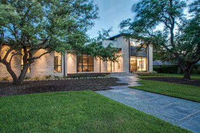 Large modern beige two-story mixed siding house exterior idea in Dallas with a hip roof and a shingle roof
