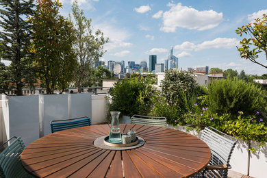 Aménagement d'une terrasse avec des plantes en pots sur le toit classique de taille moyenne avec une pergola.