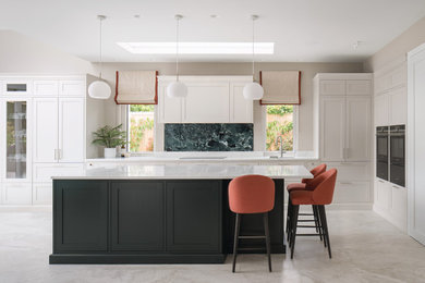 Photo of a large modern l-shaped open plan kitchen in Dublin with a built-in sink, shaker cabinets, grey cabinets, composite countertops, green splashback, porcelain splashback, black appliances, porcelain flooring, an island, grey floors and white worktops.