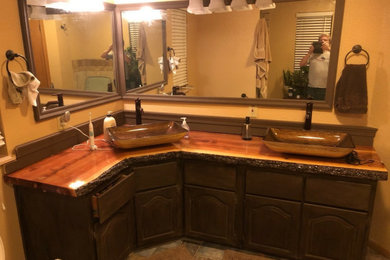 Mid-sized mountain style master ceramic tile and multicolored floor bathroom photo in Phoenix with raised-panel cabinets, dark wood cabinets, a vessel sink, wood countertops, a niche and a freestanding vanity