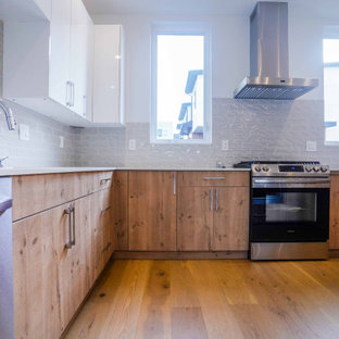 Ejemplo de cocina comedor en U, barra de cocina y gris y blanca, minimalista, grande, con fregadero bajoencimera, puertas de armario blancas, encimera de cuarcita, salpicadero verde, salpicadero de azulejos de cerámica, electrodomésticos de acero inoxidable, suelo de madera en tonos medios, península, suelo marrón, encimeras blancas, papel pintado y armarios abiertos