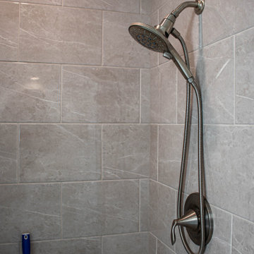 Waypoint Gray Shaker Door Cabinetry with Tiled Shower and Matching Tub Surround
