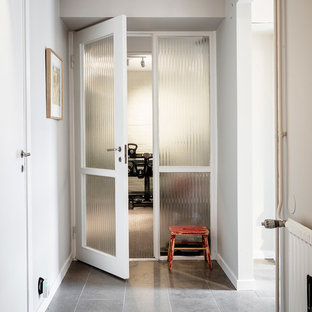 ヨーテボリの中サイズの北欧スタイルのおしゃれな地下室 (半地下 (ドアあり)、ベージュの壁、ライムストーンの床、グレーの床) の写真