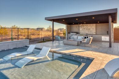 Modelo de piscina alargada moderna grande a medida en patio trasero con paisajismo de piscina y entablado