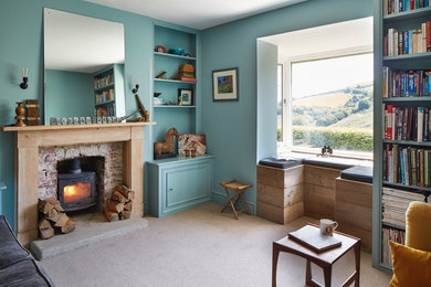 Bohemian living room in Devon with a wood burning stove and a wooden fireplace surround.