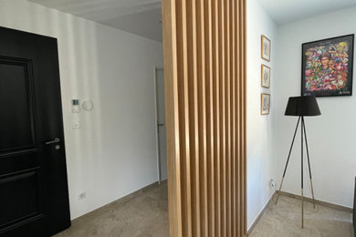 Réalisation d'un petit hall d'entrée minimaliste avec un mur blanc, un sol en carrelage de céramique, une porte simple, une porte noire et un sol gris.