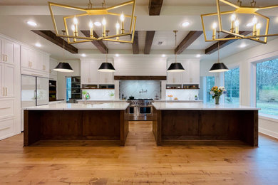 ヒューストンにある高級な広いトランジショナルスタイルのおしゃれなキッチン (エプロンフロントシンク、シェーカースタイル扉のキャビネット、中間色木目調キャビネット、クオーツストーンカウンター、白いキッチンパネル、クオーツストーンのキッチンパネル、白い調理設備、クッションフロア、茶色い床、白いキッチンカウンター、折り上げ天井) の写真