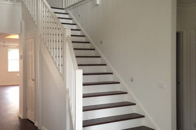 This is an example of a mid-sized transitional wood curved staircase in Melbourne with wood risers.