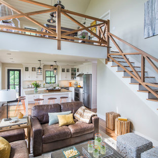 Foto di un piccolo soggiorno country con pareti bianche, parquet scuro, camino classico, cornice del camino in pietra e parete attrezzata