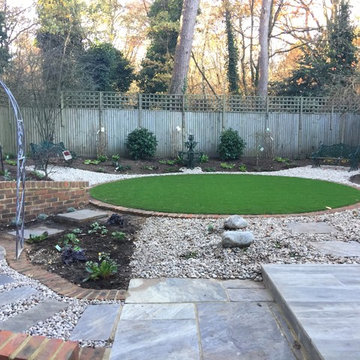 View of the whole garden, paving, brickwork, flower beds and artificial grass