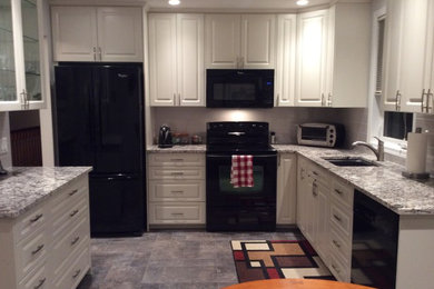 Eat-in kitchen - mid-sized traditional u-shaped slate floor and gray floor eat-in kitchen idea in Calgary with an undermount sink, raised-panel cabinets, white cabinets, granite countertops, gray backsplash, subway tile backsplash, black appliances and no island