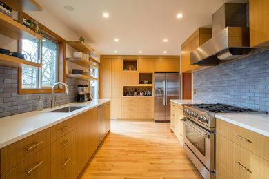 Inspiration for a 1950s medium tone wood floor kitchen remodel in Portland with quartz countertops, blue backsplash, cement tile backsplash, stainless steel appliances and white countertops