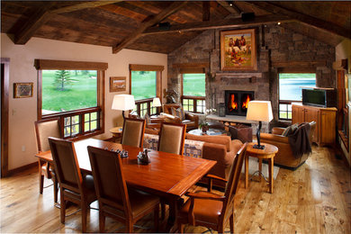 Living room - rustic medium tone wood floor living room idea in Other with a standard fireplace, a stone fireplace and a concealed tv