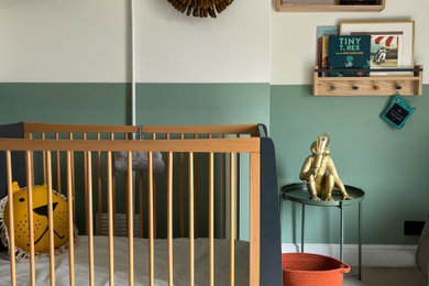 Ejemplo de habitación de bebé neutra moderna de tamaño medio con paredes verdes, moqueta, suelo beige y papel pintado