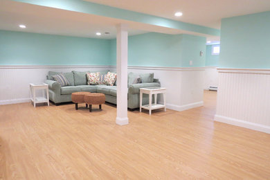 Example of a huge beach style look-out light wood floor basement design in Boston with blue walls