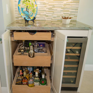 Cette photo montre une arrière-cuisine moderne avec un évier 1 bac, un placard avec porte à panneau surélevé, des portes de placard blanches, un plan de travail en quartz, une crédence en carreau de verre, un électroménager en acier inoxydable, un sol en carrelage de porcelaine, un îlot central et un plan de travail vert.