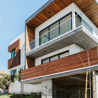 Новые идеи обустройства дома: большой, трехэтажный фасад многоквартирного дома белого цвета в современном стиле с облицовкой из дерева, плоской крышей и крышей из смешанных материалов