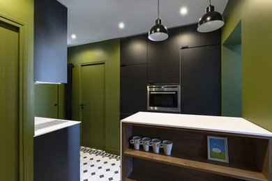 Inspiration for a small contemporary eat-in kitchen in Paris with an undermount sink, flat-panel cabinets, black cabinets, white splashback, brick splashback, panelled appliances and white benchtop.
