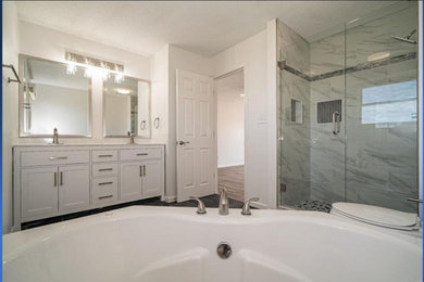 Example of a large minimalist master gray tile and stone tile double-sink, gray floor and vinyl floor wet room design in St Louis with shaker cabinets, white cabinets, a built-in vanity, a hot tub, white walls, an undermount sink and a hinged shower door