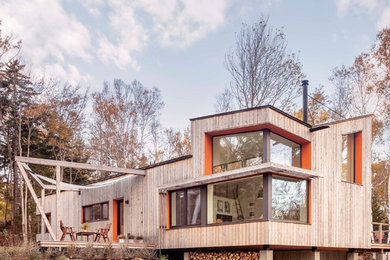 Trendy beige one-story wood house exterior photo in Other with a shed roof