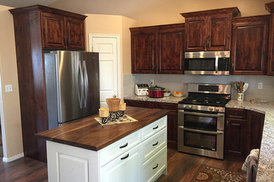 Design ideas for a mid-sized traditional u-shaped eat-in kitchen in Salt Lake City with raised-panel cabinets, dark wood cabinets, laminate benchtops, beige splashback, stainless steel appliances, medium hardwood floors and with island.
