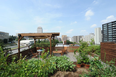 Transitional rooftop full sun formal garden in Tokyo with a vegetable garden and decking for summer.