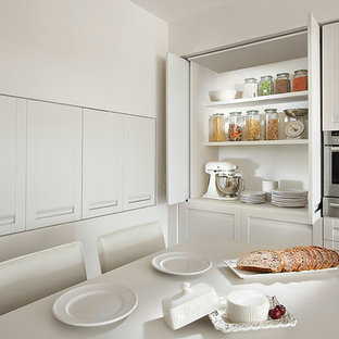 Foto di una cucina design con ante in stile shaker, ante bianche e elettrodomestici in acciaio inossidabile