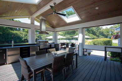 Transitional screened-in and cable railing back porch idea in Philadelphia with decking and a roof extension