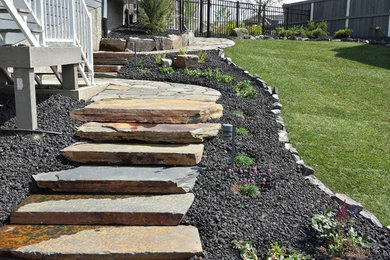 Photo of a large rustic full sun backyard stone landscaping in Edmonton for summer.