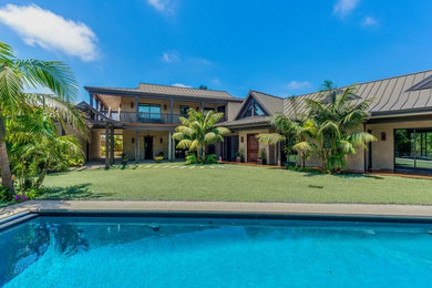 Example of a huge island style beige two-story stucco exterior home design in Los Angeles