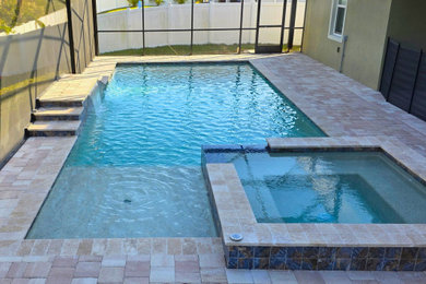 Pool fountain - large backyard concrete paver and rectangular lap pool fountain idea in Orlando