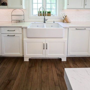 White Kitchen with Gray Quartz Countertops, Farmhouse Sink and Hardwood Floors