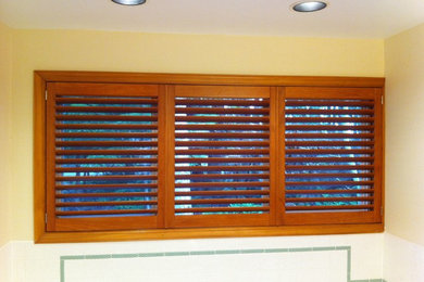 Stained wood shutter in master bath above soaking tub
