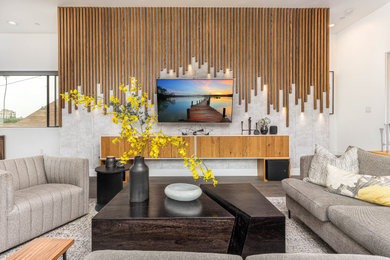 Diseño de salón abierto contemporáneo grande con paredes grises, suelo laminado y televisor colgado en la pared