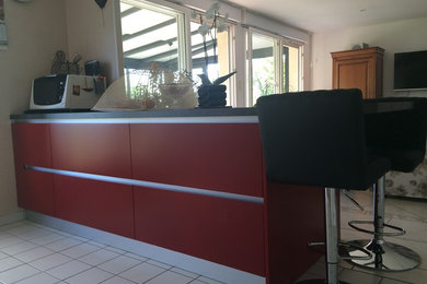 Cette image montre une petite cuisine américaine linéaire design avec un placard à porte affleurante, un plan de travail en stratifié, un électroménager en acier inoxydable et un plan de travail gris.