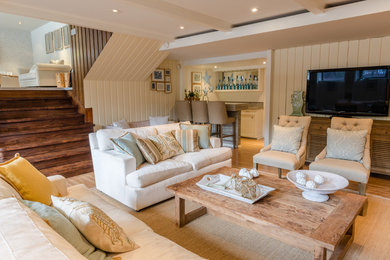 Example of a mid-sized beach style enclosed light wood floor living room library design in Montreal with beige walls, a standard fireplace, a brick fireplace and a wall-mounted tv