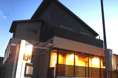 Photo of a mid-sized modern two-storey house exterior in Osaka with a shed roof and a tile roof.