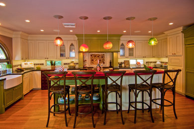 Eat-in kitchen - huge traditional u-shaped light wood floor eat-in kitchen idea in Los Angeles with a farmhouse sink, raised-panel cabinets, white cabinets, quartz countertops, green backsplash, ceramic backsplash, paneled appliances and an island