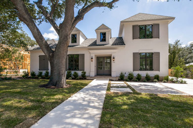 Large french country white two-story stucco house exterior idea in Other with a hip roof and a shingle roof