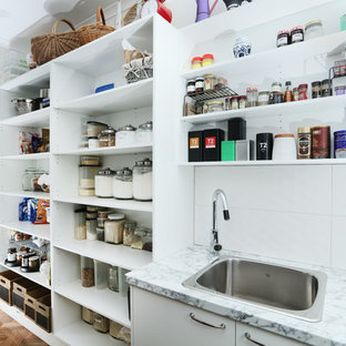 Zweizeilige, Mittelgroße Klassische Küche mit Kücheninsel, Vorratsschrank, Einbauwaschbecken, flächenbündigen Schrankfronten, weißen Schränken, Laminat-Arbeitsplatte, Küchengeräten aus Edelstahl und dunklem Holzboden in Melbourne