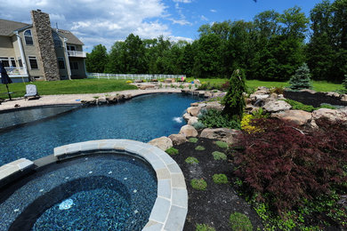 Hot tub - large transitional backyard stone and custom-shaped lap hot tub idea in New York
