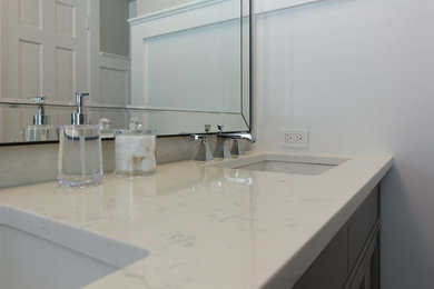 Mid-sized transitional master ceramic tile and gray floor bathroom photo in Chicago with recessed-panel cabinets, gray cabinets, a two-piece toilet, gray walls, an undermount sink and solid surface countertops