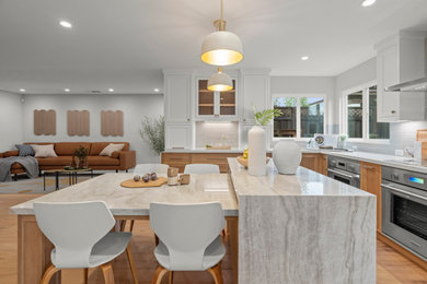 Eat-in kitchen - large transitional u-shaped medium tone wood floor and brown floor eat-in kitchen idea in San Francisco with a double-bowl sink, shaker cabinets, medium tone wood cabinets, solid surface countertops, gray backsplash, porcelain backsplash, stainless steel appliances, two islands and multicolored countertops