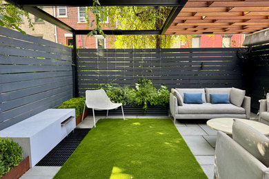 Photo of a mid-sized modern backyard wood fence landscaping in New York with a pergola.