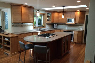 Mid-sized elegant l-shaped medium tone wood floor eat-in kitchen photo in Portland with flat-panel cabinets, light wood cabinets, an island, a double-bowl sink, concrete countertops, white backsplash, ceramic backsplash and stainless steel appliances