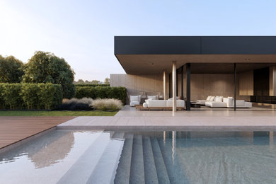 Immagine di una piscina minimal rettangolare nel cortile laterale con pavimentazioni in pietra naturale