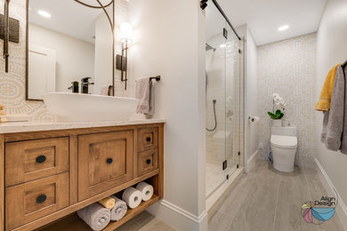 Mid-sized eclectic multicolored tile and cement tile porcelain tile, beige floor and single-sink double shower photo in Other with shaker cabinets, medium tone wood cabinets, a bidet, gray walls, a vessel sink, quartz countertops, a hinged shower door, beige countertops, a niche and a floating vanity