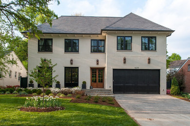 Large transitional beige three-story stucco house exterior idea in DC Metro with a hip roof and a shingle roof