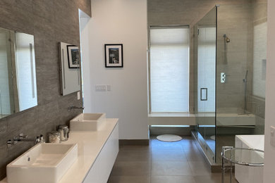 Example of a large trendy master gray tile and ceramic tile ceramic tile, gray floor and double-sink bathroom design in Los Angeles with flat-panel cabinets, white cabinets, a two-piece toilet, white walls, a vessel sink, quartzite countertops, a hinged shower door, white countertops and a floating vanity