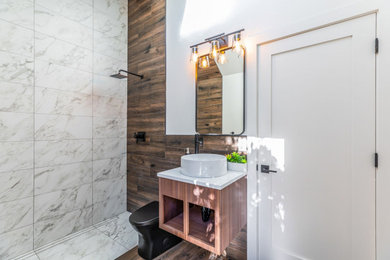 Example of a mid-sized island style bathroom design in Phoenix with a one-piece toilet and a wall-mount sink